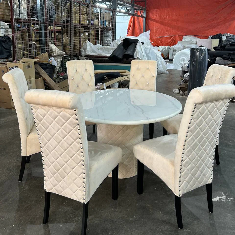 Chester round marble dining table displayed with matching quilted dining chairs