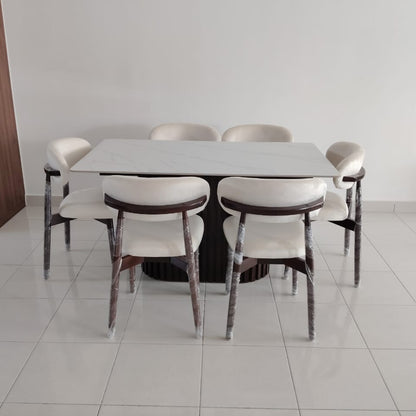 A modern dining set consisting of a rectangular white table and six chairs with white upholstered seats and backs, dark wood-look frames, and weathered silver metal legs, shown in a minimalist room with white tiled floors and a white wall.