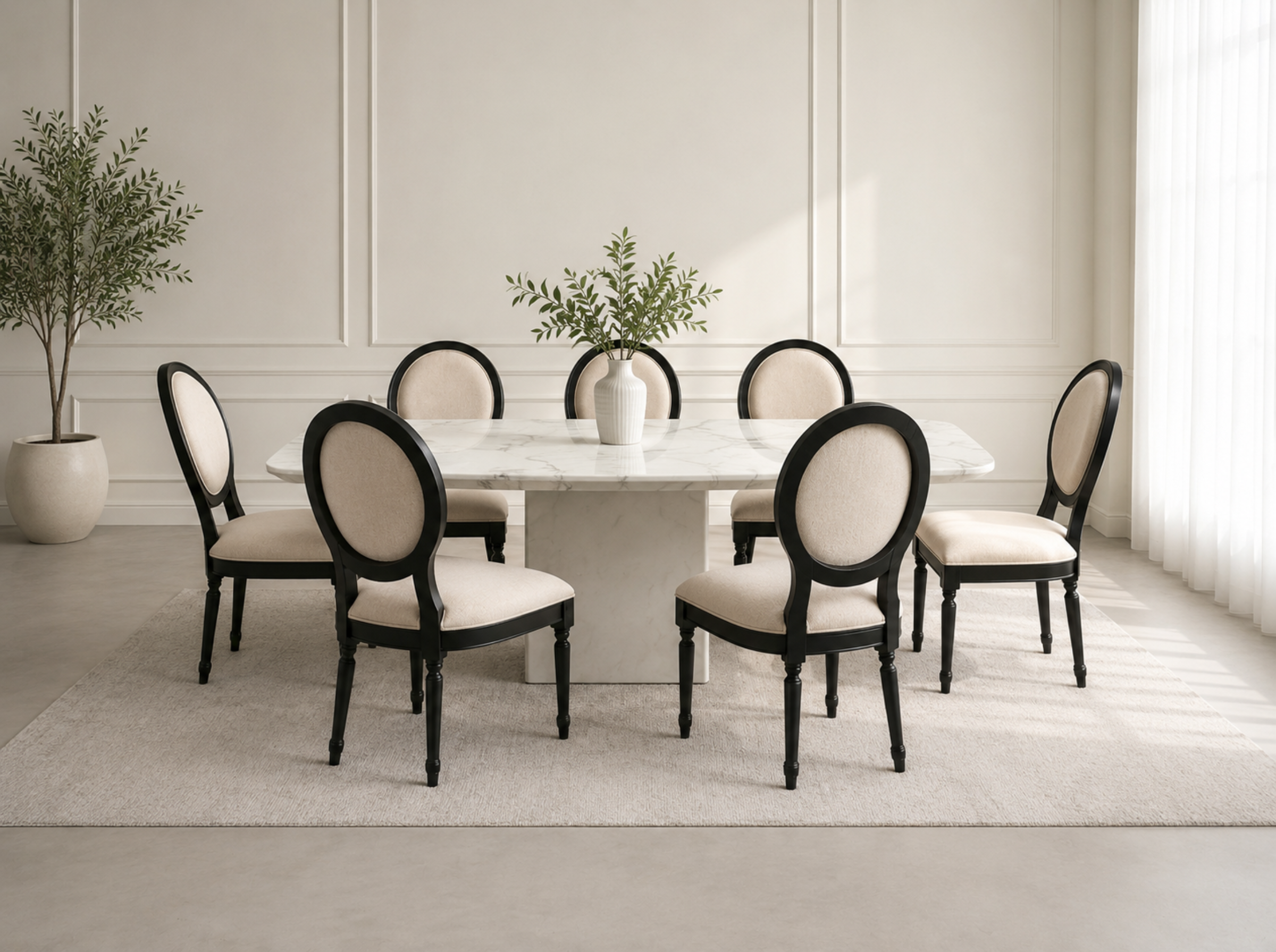 A dining set featuring a white marble-top table and six matching chairs with black frames and cream upholstered seats, arranged on a light rug in a bright, modern dining room.